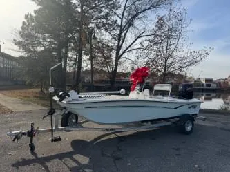 The Image of 2025 Mako Pro Skiff 17 CC boat with red bow on trailer, outdoors. - 0