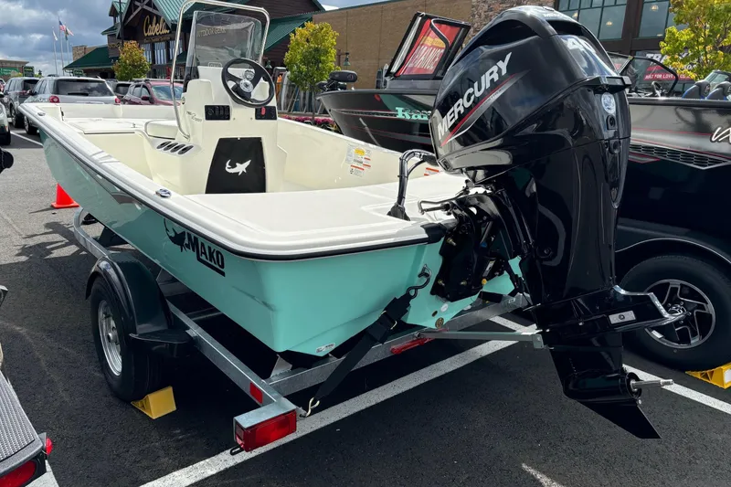 Slide: The Image of 2025 Mako Pro Skiff 15 CC boat with Mercury engine on trailer in parking lot. - 0