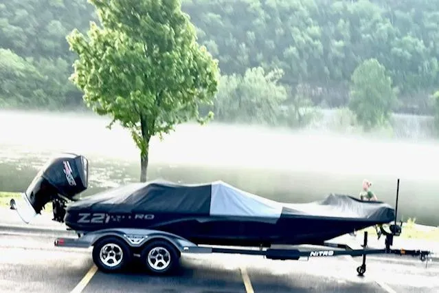 Slide: The Image of 2025 Nitro Z21 XL boat on trailer by misty lake and trees. - 110