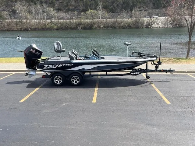 Slide: The Image of 2025 Nitro Z20 XL boat parked by a scenic river. - 1