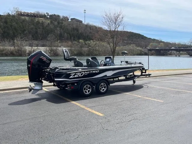 Slide: The Image of 2025 Nitro Z20 XL boat parked by a scenic riverside. - 2