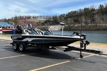 Slide: The Image of 2025 Nitro Z20 XL boat parked by a scenic lake with trees in the background. - 3