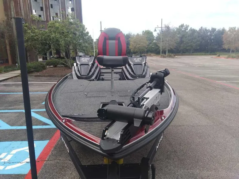 Slide: The Image of 2025 Nitro Z21 XL bass boat parked in an empty lot. - 7