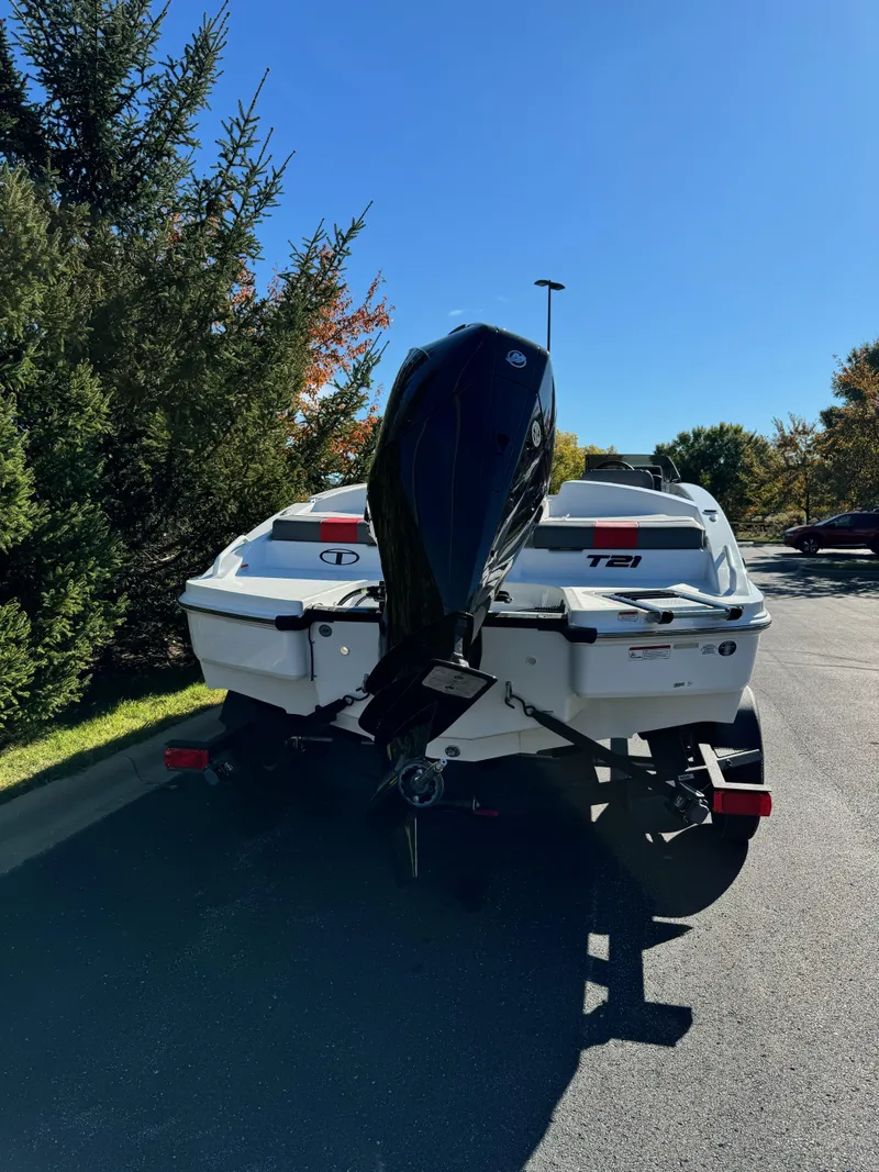Slide: The Image of 2025 Tahoe T21 boat on trailer, parked outdoors under clear blue sky. - 4