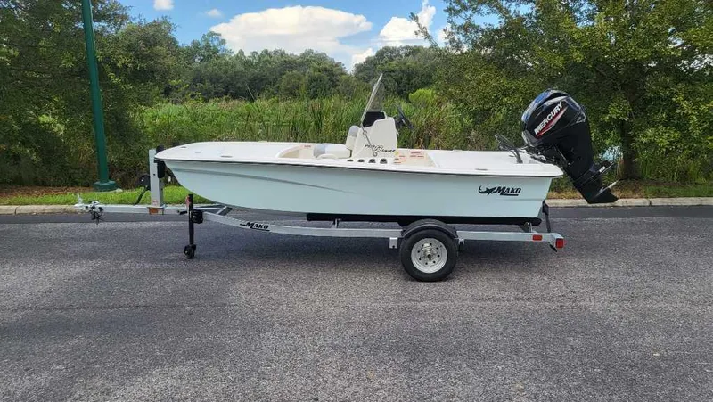 Slide: The Image of 2025 Mako Pro Skiff 13 CC boat on trailer, parked outdoors. - 2