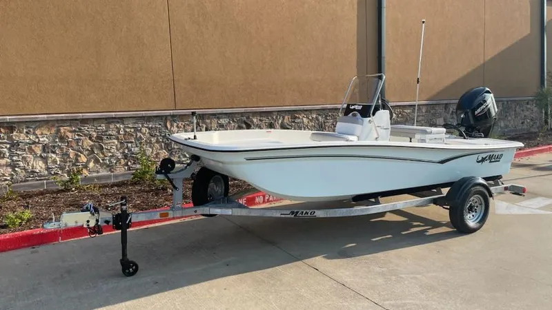 Slide: The Image of 2025 Mako Pro Skiff 15 CC boat on trailer, parked outdoors. - 1