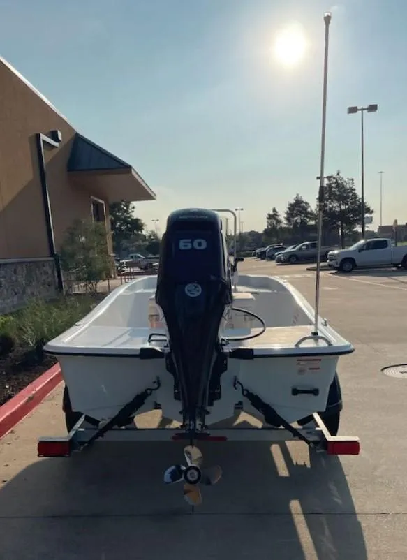 Slide: The Image of 2025 Mako Pro Skiff 15 CC boat on trailer, parked outdoors under bright sunlight. - 6