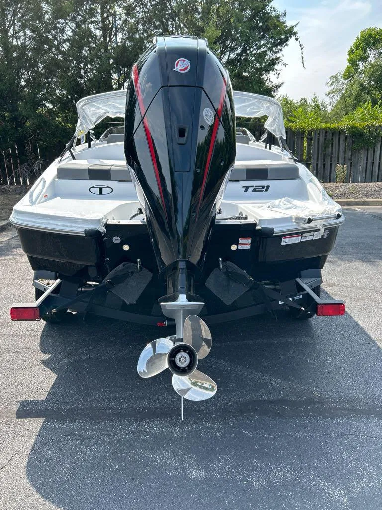 Slide: The Image of 2025 Tahoe T21 boat, rear view with outboard motor, parked outdoors. - 2