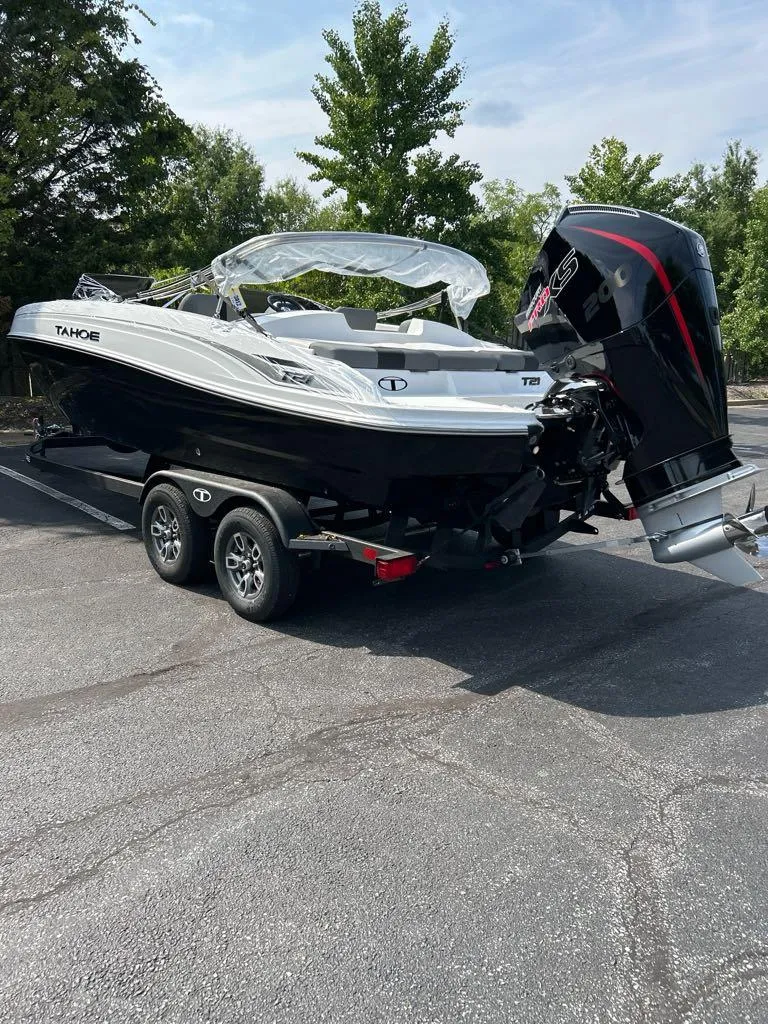 Slide: The Image of 2025 Tahoe T21 boat on trailer, parked outdoors, with trees in the background. - 3