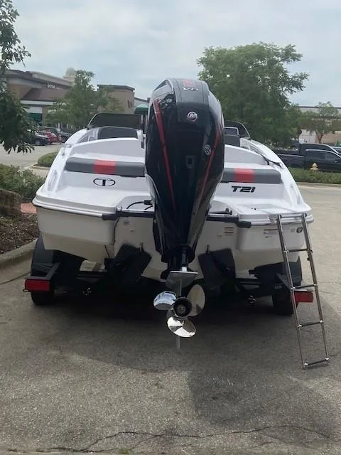 Slide: The Image of 2025 Tahoe T21 boat with outboard motor and ladder, parked outdoors. - 5