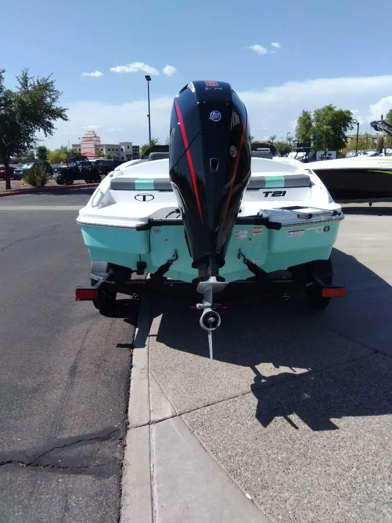 Slide: The Image of 2025 Tahoe T21 boat with outboard motor, parked on a sunny day. - 1