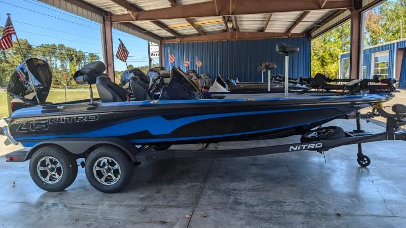 The Image of 2025 Nitro Z19 Pro boat in showroom, blue and black design, on trailer. - 0