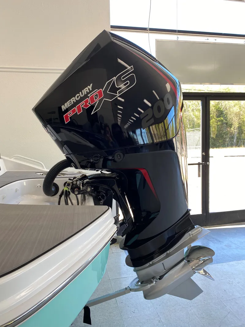 Slide: The Image of 2025 Tahoe T21 boat with Mercury Pro XS outboard motor in showroom. - 2