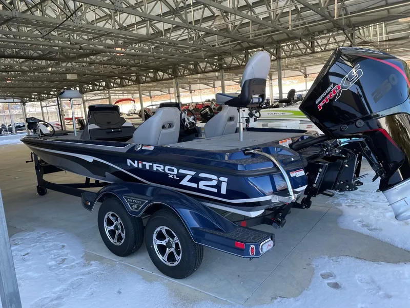 Slide: The Image of 2025 Nitro Z21 XL boat in storage, featuring dual seats and powerful outboard motor. - 2