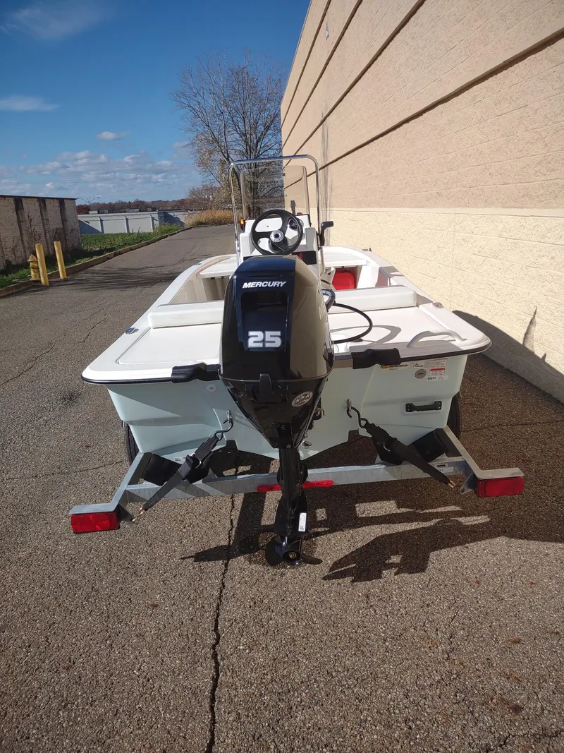 Slide: The Image of 2025 Mako Pro Skiff 13 CC boat with Mercury 25 engine, parked outdoors. - 4