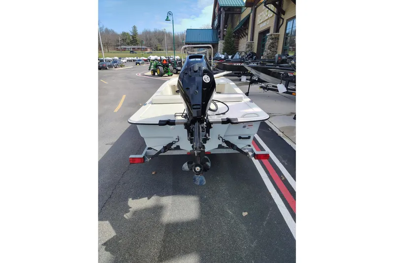 Slide: The Image of 2025 Mako Pro Skiff 13 CC boat with outboard motor, parked outdoors. - 8