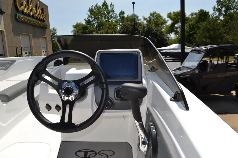 Slide: The Image of 2025 Tahoe T21 boat dashboard with steering wheel and control panel. - 2