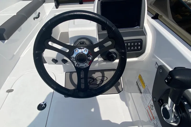 Slide: The Image of Steering wheel and dashboard of 2025 Tahoe T21 boat, featuring modern controls. - 2