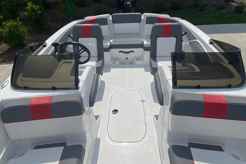 Slide: The Image of 2025 Tahoe T21 boat interior with gray and red seating, dual windshields, and steering wheel. - 3