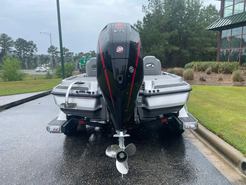 Slide: The Image of 2025 Nitro Z20 XL boat with powerful outboard motor on a wet road. - 2