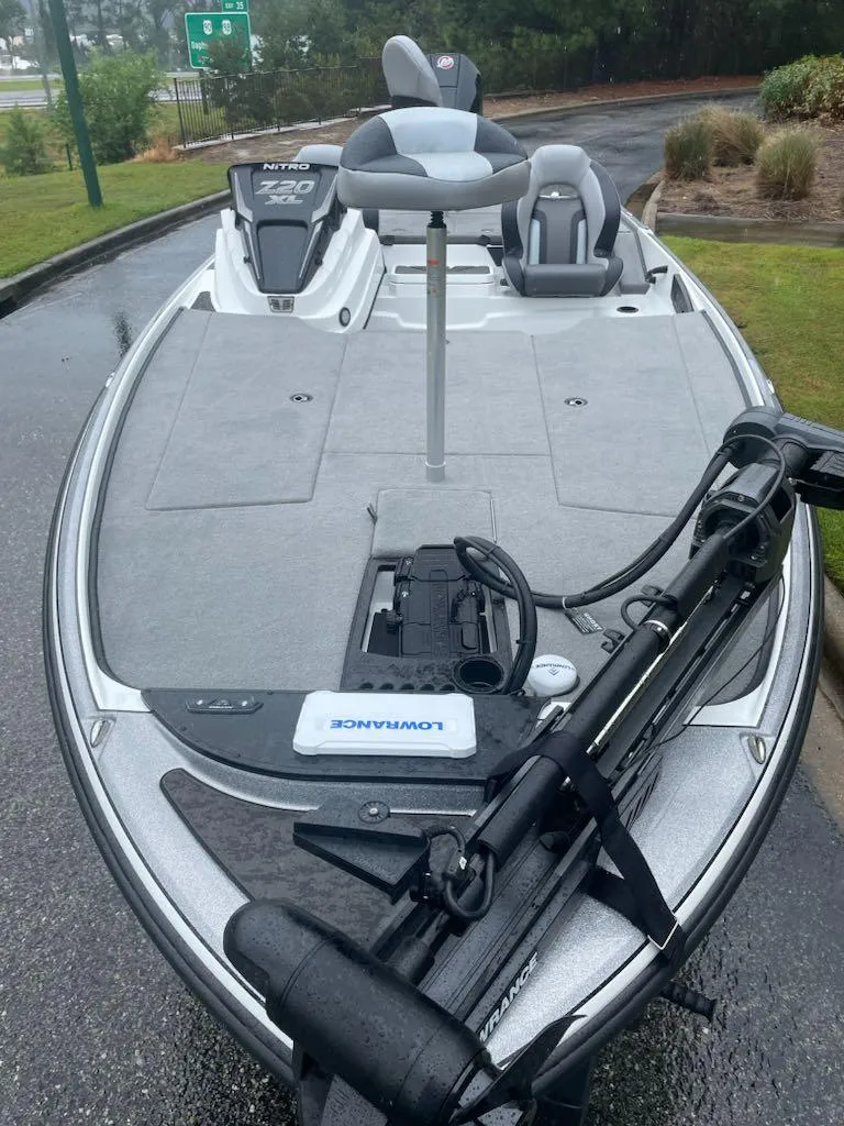 Slide: The Image of 2025 Nitro Z20 XL fishing boat with trolling motor on a wet surface. - 3