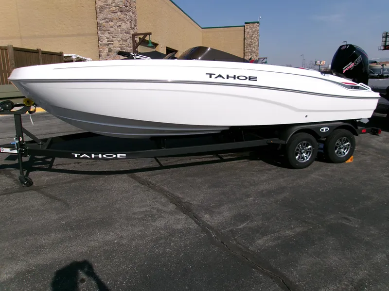Slide: The Image of 2025 Tahoe T21 boat on trailer, parked outdoors, side view. - 2
