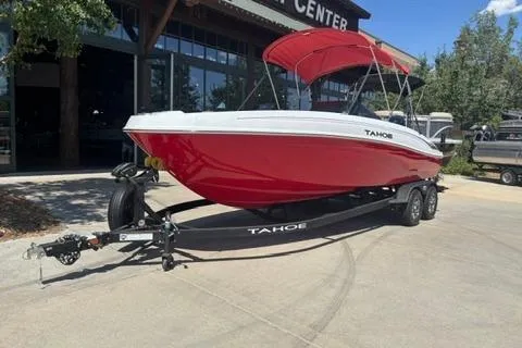 Slide: The Image of 2025 Tahoe T21 boat with red hull on trailer, parked outdoors. - 1