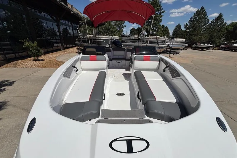 Slide: The Image of 2025 Tahoe T21 boat with red canopy and spacious seating, parked outdoors. - 4