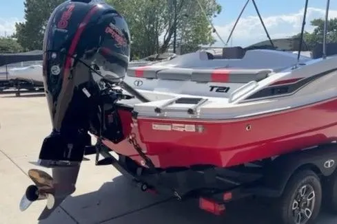 Slide: The Image of 2025 Tahoe T21 boat with powerful outboard motor, parked on a trailer. - 12