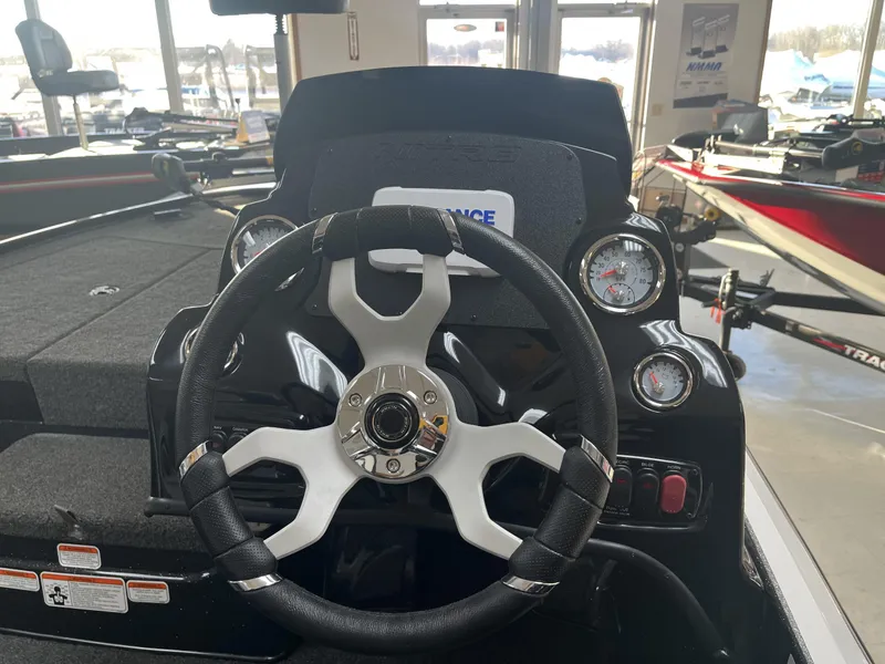 Slide: The Image of Steering wheel and dashboard of a 2025 Nitro Z17 boat in showroom. - 2