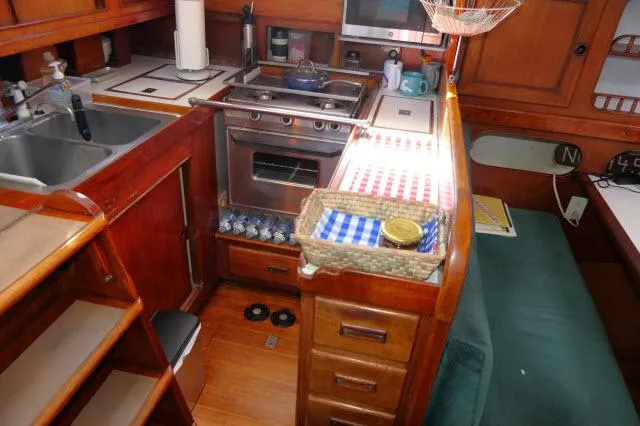 Slide: The Image of 1976 Peterson 44 yacht kitchen with wooden cabinetry and modern appliances. - 10