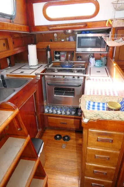 Slide: The Image of 1976 Peterson 44 yacht kitchen with wood cabinetry and modern appliances. - 11