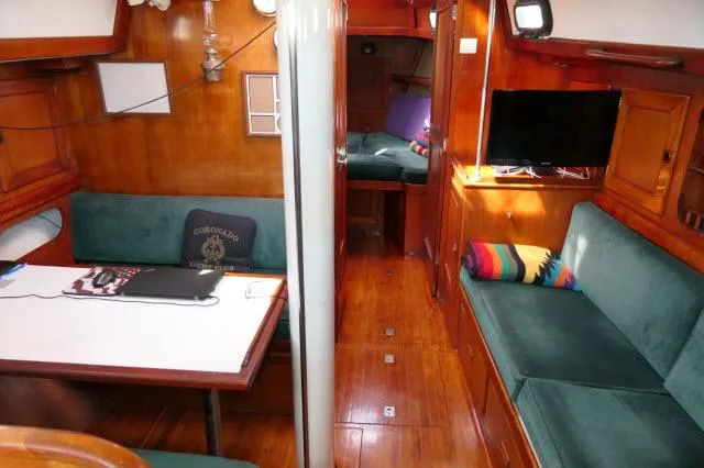 Slide: The Image of Interior of a 1976 Peterson 44 yacht with green seating and wooden finishes. - 2