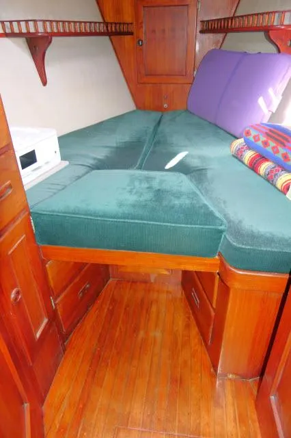 Slide: The Image of 1976 Peterson 44 yacht interior with green cushions and wooden cabinetry. - 20