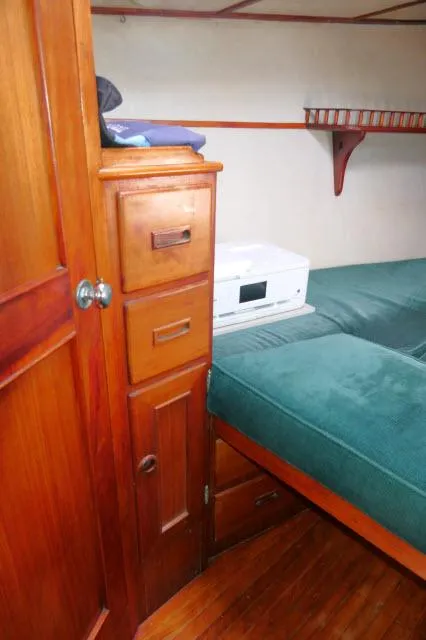 Slide: The Image of Cozy cabin interior of 1976 Peterson 44 sailboat with wooden storage and green bedding. - 21