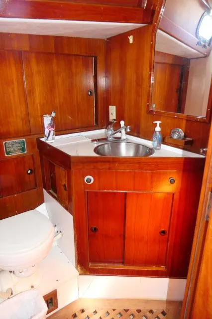 Slide: The Image of 1976 Peterson 44 yacht bathroom with wooden cabinetry and stainless steel sink. - 22