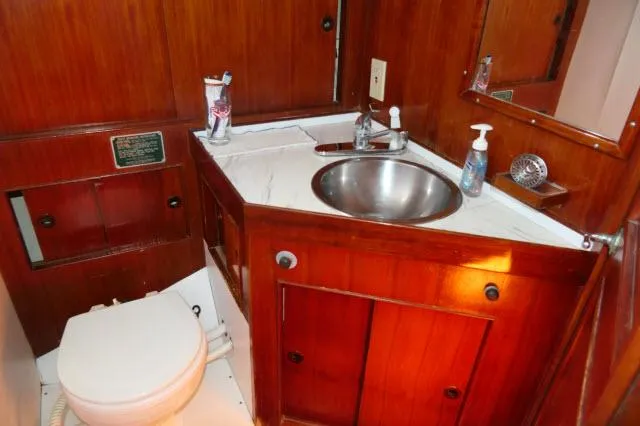 Slide: The Image of 1976 Peterson 44 yacht bathroom with wooden cabinetry and stainless steel sink. - 23
