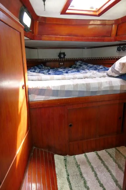 Slide: The Image of Cozy cabin interior of 1976 Peterson 44 sailboat with wooden furnishings and bed. - 24