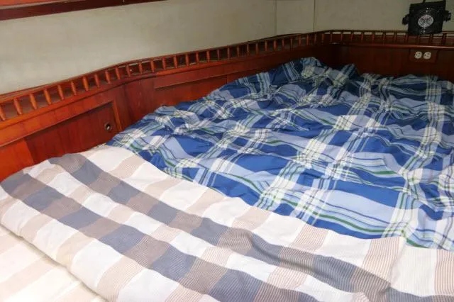 Slide: The Image of Cozy cabin bed with plaid bedding in a 1976 Peterson 44 sailboat. - 26