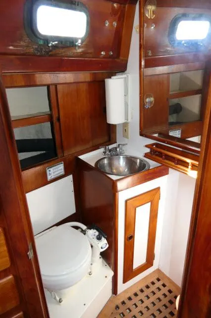 Slide: The Image of 1976 Peterson 44 yacht bathroom with wooden cabinetry and stainless steel sink. - 30