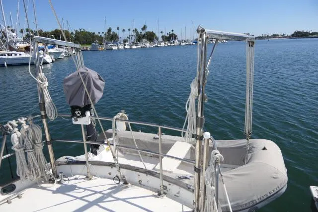 Slide: The Image of 1976 Peterson 44 sailboat with dinghy in a marina setting. - 33