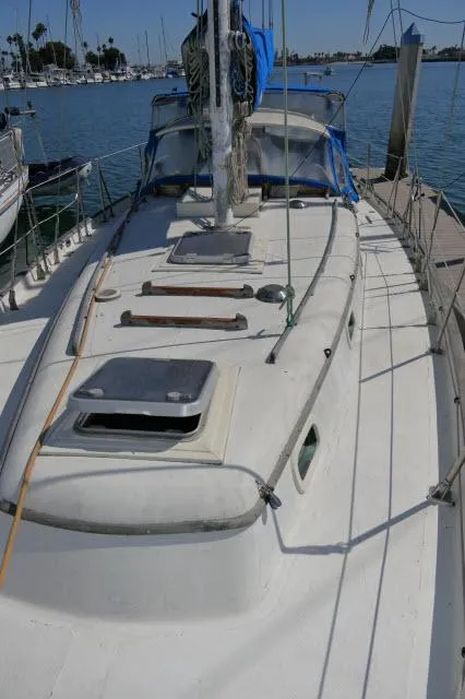 Slide: The Image of 1976 Peterson 44 sailboat docked at marina, showing deck and mast. - 38