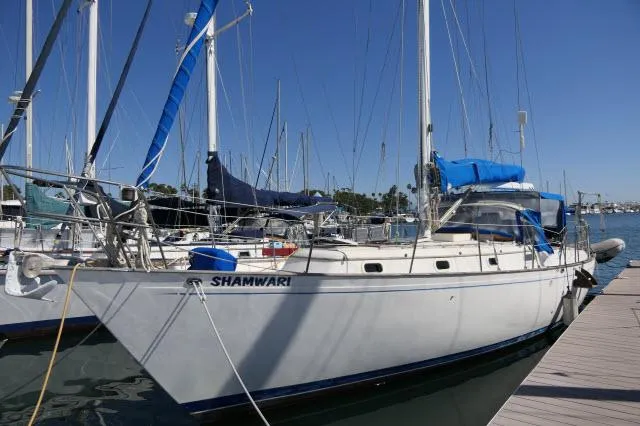 Slide: The Image of 1976 Peterson 44 sailboat docked in marina, clear blue sky. - 47