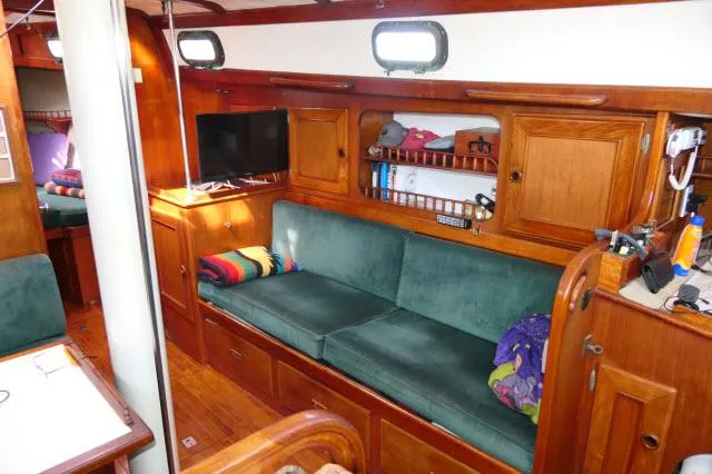 Slide: The Image of Cozy interior of a 1976 Peterson 44 sailboat with green seating and wooden cabinetry. - 5