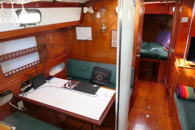Slide: The Image of Interior of a 1976 Peterson 44 sailboat with wooden furnishings and cozy seating area. - 6