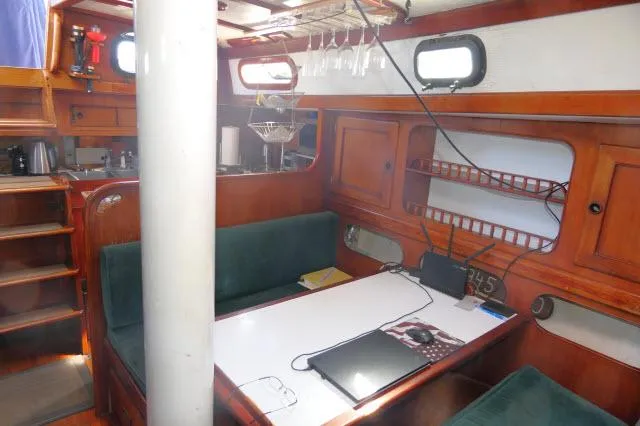 Slide: The Image of 1976 Peterson 44 sailboat interior with wooden cabinetry and green seating. - 7