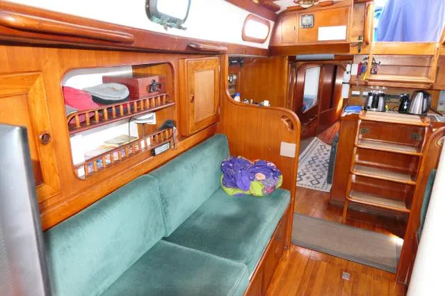 Slide: The Image of 1976 Peterson 44 yacht interior with wooden finish and green sofa. - 8