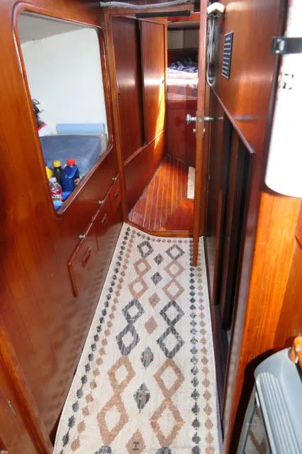 Slide: The Image of Interior of a 1976 Peterson 44 yacht with wooden paneling and patterned carpet. - 9