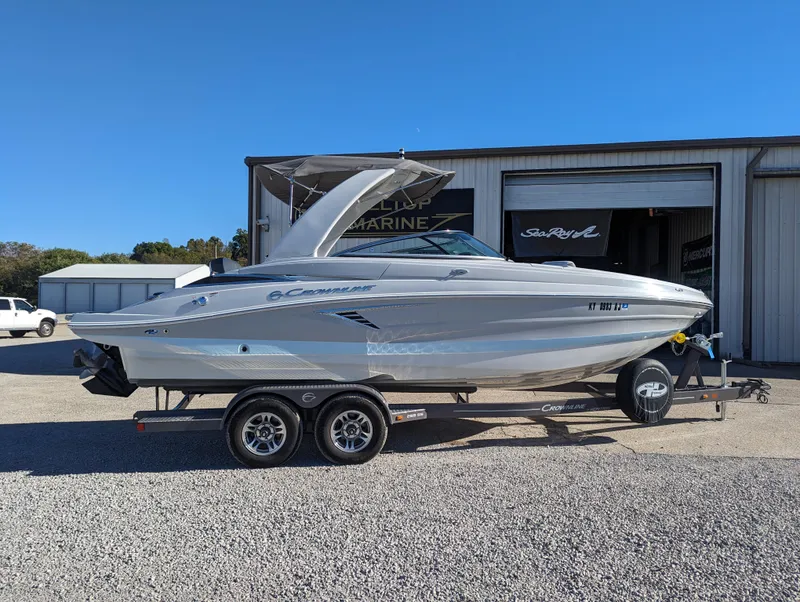 Slide: The Image of 2023 Crownline 260 SS boat on trailer, parked outside a marine shop. - 11