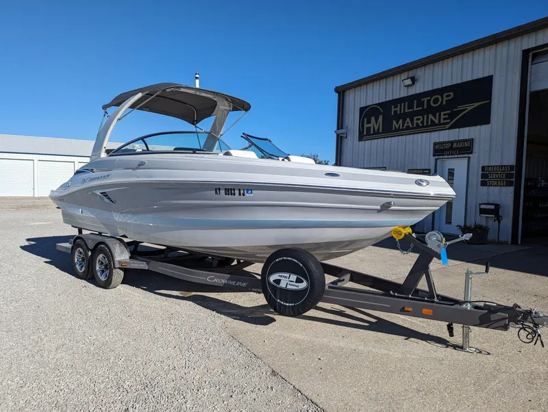 Slide: The Image of 2023 Crownline 260 SS boat on trailer outside Hilltop Marine. - 12